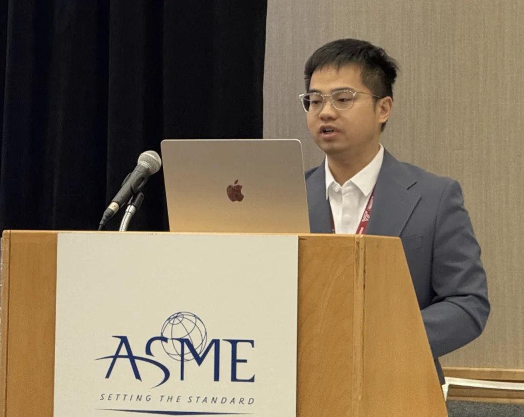 Songhua Huang delivering an oral presentation at an ASME podium